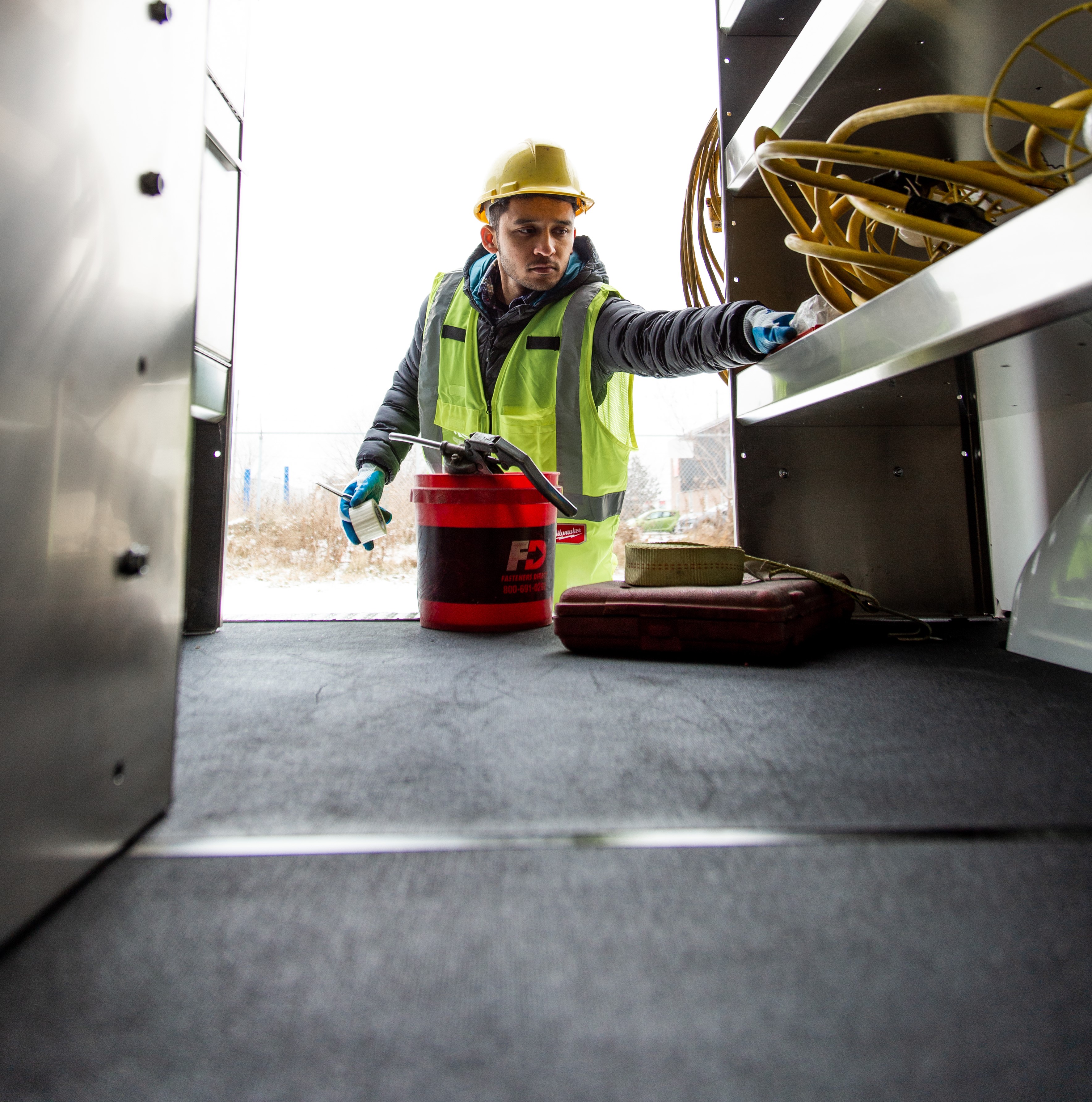 A service worker being productive and efficient in a van lined with safe and durable Legend floors and liners