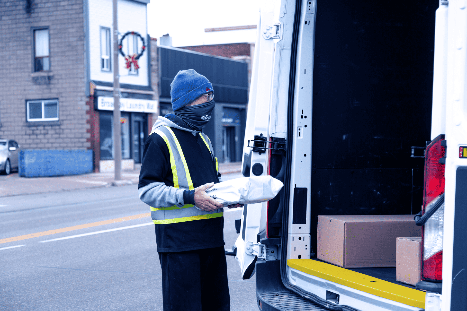 A service worker loading packages in a van during cold weather