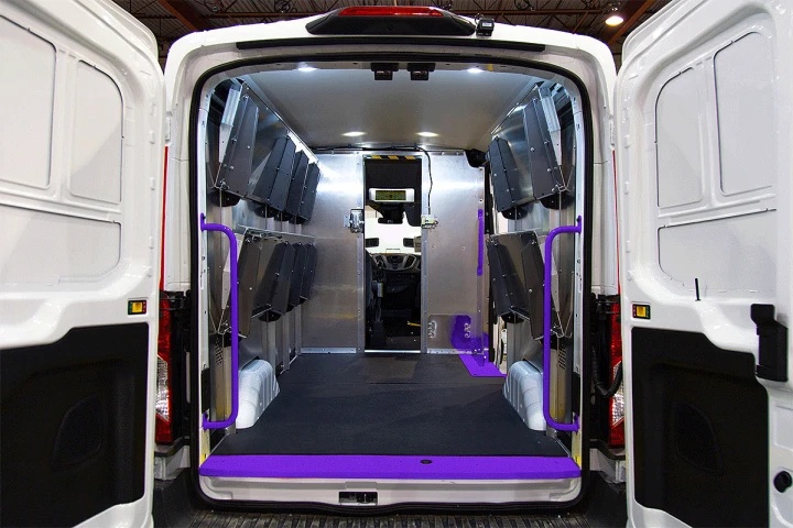 The back of a transit van with the doors wide open revealing Legend steel doorway thresholds and grab handles. The products are alternating between various colours to show that coloring is customizable based on fleet colors.